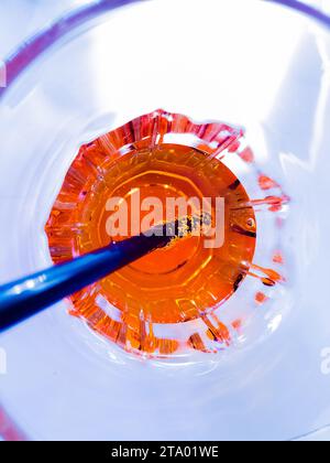 Blick von oben auf ein Glas Spritz Aperitif aperol Orangencocktail auf blauem Lounge Disco Licht, Urlaub und Sommer Konzept Stockfoto