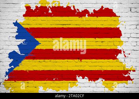 Flagge kataloniens gelber, roter Streifen und Stern mit Aquarellspritzeffekt auf weißem Backsteinmauerhintergrund, nationales katalanisches Symbol für Separatismus Unabhängigkeit vom spanischen Konzept Stockfoto