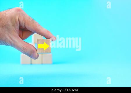 Hand. Holzwürfel mit Pfeil. Problemkrise überwinden und Weg zum Erfolg Konzept. Getreu oder nur so, Richtungskonzept Stockfoto
