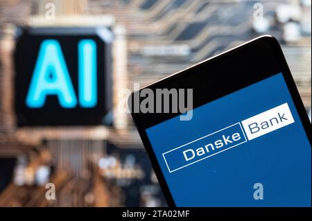 In dieser Fotoabbildung wird das dänische Danske Bank-Logo (CPH: DANSKE) auf einem Smartphone mit einem Chip für künstliche Intelligenz (KI) und einem Symbol im Hintergrund angezeigt. Stockfoto