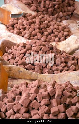 Eine große Ausstellung handgemachter Schokoladentrüffel, die in Kakaopulver überzogen und in einem handwerklichen Trüffelkonditorgeschäft ausgestellt sind Stockfoto