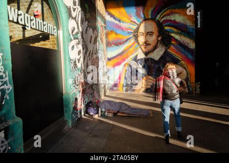 Ein Tourist, der ein großes Wandbild von William Shakespeare auf Londons Southbank fotografiert. Das Kunstwerk befindet sich an der Seite eines Wagamama Restaurants Stockfoto