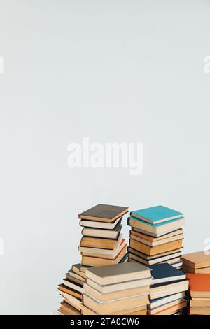 Viele Stapel von Lehrbüchern auf weißem Schulbibliothekenhintergrund Stockfoto