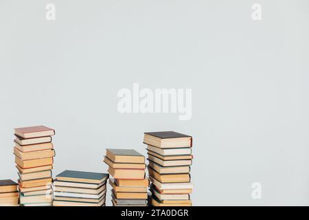 Viele Stapel von Lehrbüchern auf weißem Schulbibliothekenhintergrund Stockfoto
