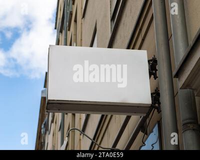 Leeres Schild an der Fassade eines Unternehmens im Gebäude. Vorlage zum Testen eines Logos oder Schildes neben einer Wand. Leeres Modell zur Werbung für eine Marke. Stockfoto