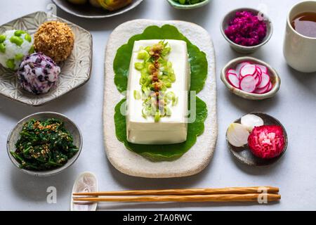 Japanisches Mittagessen mit Seidentofu, Onigiri, Spinatgomae, Miso-Lauch und eingelegtem Gemüse Stockfoto