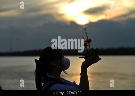Bangkok, Thailand. November 2023. Eine Frau bereitet sich darauf vor, eine Wasserlaterne während des Loy Krathong Festivals in Bangkok, Thailand, am 27. November 2023 freizugeben. Quelle: Rachen Sageamsak/Xinhua/Alamy Live News Stockfoto