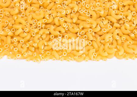 Ungekochte Chifferi Rigati Pasta auf dem weißen Tisch. Fett und ungesunde Lebensmittel. Klassische Trockene Makkaroni. Italienische Kultur und Küche. Rohe Pasta Stockfoto