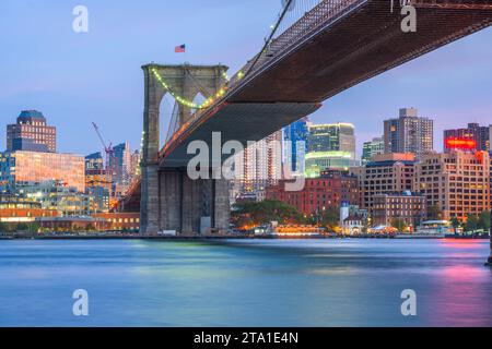 Die Brooklyn Bridge, New York City, USA, erstreckt sich in der Abenddämmerung über den East River in Richtung Brooklyn. Stockfoto