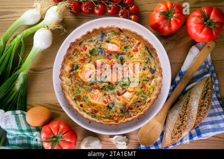 Traditionelle Lachsquiche mit Brokkoli und Gemüse. Stockfoto