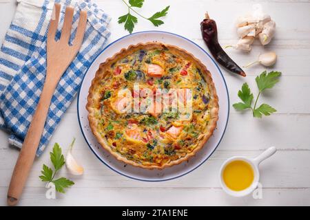 Traditionelle Lachsquiche mit Brokkoli und Gemüse. Stockfoto