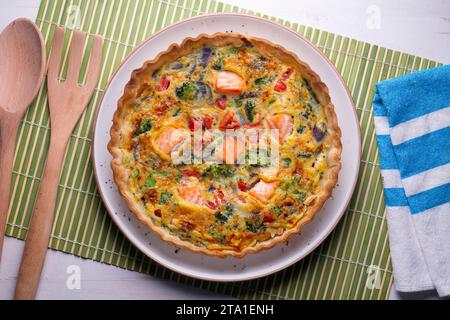 Traditionelle Lachsquiche mit Brokkoli und Gemüse. Stockfoto