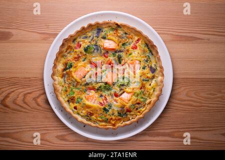 Traditionelle Lachsquiche mit Brokkoli und Gemüse. Stockfoto