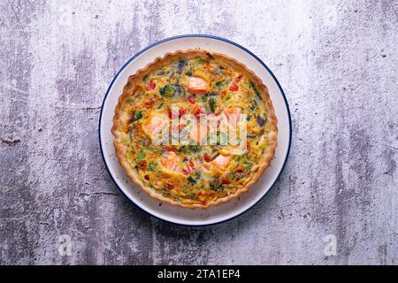 Traditionelle Lachsquiche mit Brokkoli und Gemüse. Stockfoto
