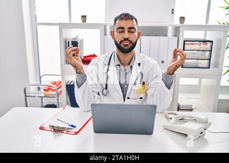 Junger hispanischer Arzt, der in der Klinik Yoga-Übungen macht Stockfoto