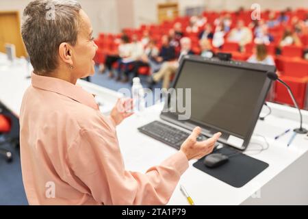 Reife weibliche Rednerin auf der Podiumsdiskussion während der Besprechung des Publikums Stockfoto