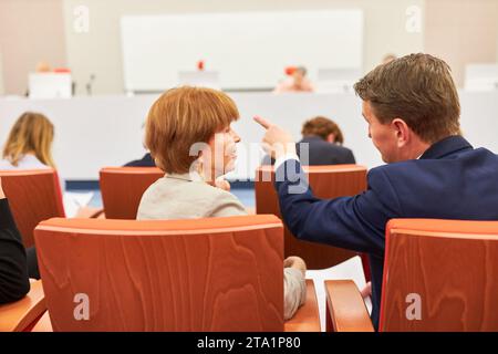 Geschäftsfrau und Geschäftsmann diskutieren während der Geschäftskonferenz im Auditorium Stockfoto