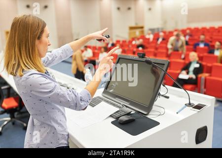 Weibliche Rednerin auf der Podiumsdiskussion, die Fragen auf einer Geschäftskonferenz im Convention Center beantwortet Stockfoto