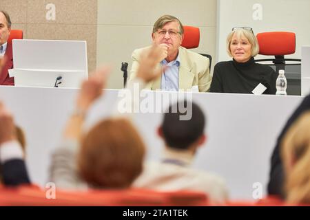 Männliche und weibliche Redner auf einer Konferenz, die Fragen von erhabenen Händen von Zuschauern auf einer Geschäftsveranstaltung beantworten Stockfoto