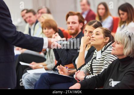 Professionelle Person, die während der Konferenz im Kongresszentrum Fragen an Geschäftsfrau stellt Stockfoto