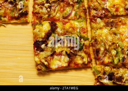 St. Pizza im Louis-Stil, hausgemacht auf hölzernem Hintergrund, mit Käse, Pfeffer, Speck, Zwiebeln Stockfoto