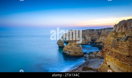 Kalksteinklippen am Strand Praia da Marinha in der Abenddämmerung in der Algarve im Süden Portugals Stockfoto