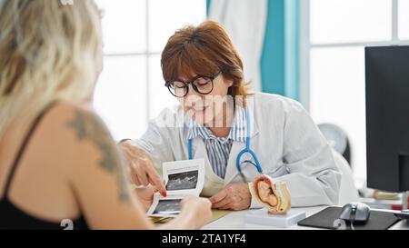 Mittelalterliche Ärztin und Patientin zeigen Ultraschallkind in der Klinik Stockfoto