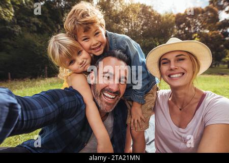 Freundliche Familie selfie machen. Eltern Spaß mit Ihren Kindern draußen im Park. Nette Familie mit Picknick. Stockfoto