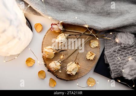 Die Verwendung toter Blumen in der Inneneinrichtung ist schlecht Feng Shui. Getrocknete Rosen auf Holzscheibe im Heim-Zimmer. Stockfoto
