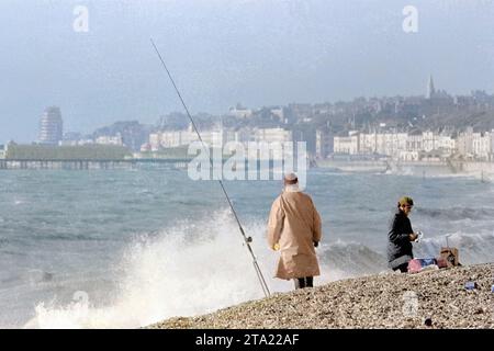 Farbiges Foto eines Angelwettbewerbs am Strand von Hastings mit dem Pier im Hintergrund 1971. Stockfoto