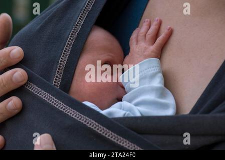 Säugling in Schlinge mit Mutter, Mecklenburg-Vorpommern, Deutschland Stockfoto