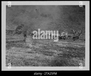 Die Position der vietnamesischen Regierung auf dem Bild zeigt einen trüben Hang aufgrund von Bomben- und Raketenangriffen. Eine Rakete, die von einem Huey-Hubschrauber abgefeuert wurde, ist schwach sichtbar. Ende November 1963 wurden vietnamesische Armeetruppen mit Hubschraubern der US Marine für einen vertikalen Angriff auf den Viet Cong südwestlich von da Nang in Vietnam eingesetzt. Stockfoto