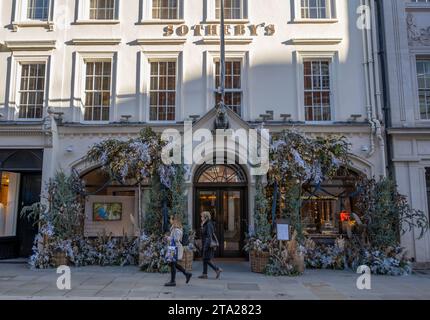 London, Großbritannien. November 2023. Unternehmen in der New Bond Street schmücken die Fassaden mit üppigen Festvorstellungen zu Weihnachten 2023. Der Eingang des Auktionshauses von Sotheby ist mit traditionellem Lametta, Frost und Lichtern geschmückt. Quelle: Malcolm Park/Alamy Live News Stockfoto