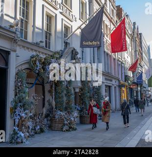 London, Großbritannien. November 2023. Unternehmen in der New Bond Street schmücken die Fassaden mit üppigen Festvorstellungen zu Weihnachten 2023. Der Eingang des Auktionshauses von Sotheby ist mit traditionellem Lametta, Frost und Lichtern geschmückt. Quelle: Malcolm Park/Alamy Live News Stockfoto