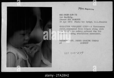 Ein vietnamesisches Kind wird am 29. April 1975 von Saigon und Phnom Penh aus mit seiner Familie an Bord der USS Hancock evakuiert, um die Sicherheit während des Vietnamkriegs zu gewährleisten. Stockfoto