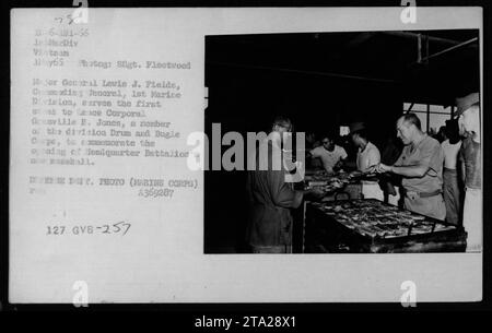 Major General Levis J. Fields, 1. Marine-Division, serviert das erste Steak an Lance Corporal Gronville B. Jones, ein Mitglied des Drum and Bugle Corps, während der Eröffnung der neuen Fossball-Anlage des Hauptquartier-Bataillons in MerDiv Vietnam am 1. Mai 1966. Foto von SSgt. Fleetwood, mit freundlicher Genehmigung des Marine Corps, zeigt Messmen in Aktion. Stockfoto