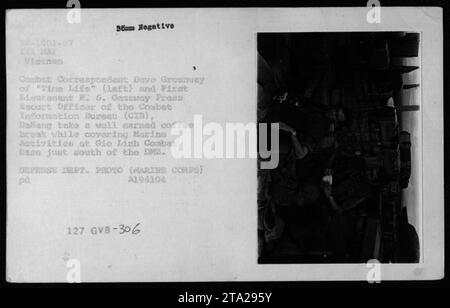 Dave Greenway und First Lieutenant B.S. Gazaway machen eine Kaffeepause, während sie über Marineaktivitäten auf der Gio Linh Combat Base südlich der DMZ in Vietnam berichten und die amerikanischen Militäroperationen während des Vietnamkriegs dokumentieren. Stockfoto