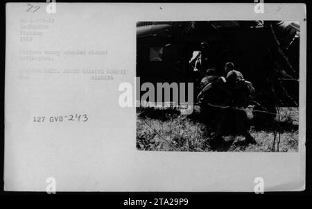 Die Marines helfen 1967 bei der Evakuierung verwundeter Soldaten in Vietnam. Das Foto fängt den Moment ein, in dem die Marines die Verletzten an Bord eines Hubschraubers zur medizinischen Evakuierung tragen. Das Bild wurde während des Vietnamkriegs aufgenommen und zeigt die militärischen Aktivitäten und die Bemühungen, Menschen in Not medizinische Hilfe zu leisten. (59 Wörter) Stockfoto