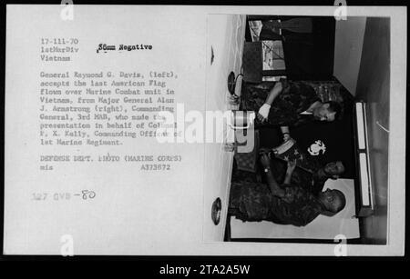General Raymond G. Davis, links, akzeptiert die letzte amerikanische Flagge, die von General Alan J. Armstrong auf der rechten Seite über eine Marine-Kampfeinheit in Vietnam geflogen wurde. Die Präsentation erfolgte im Namen von Oberst P. X. Kelly, Commanding Officer des 1st Marine Regiment. Dieses Foto wurde 1970 während einer Zeremonie aufgenommen. Stockfoto