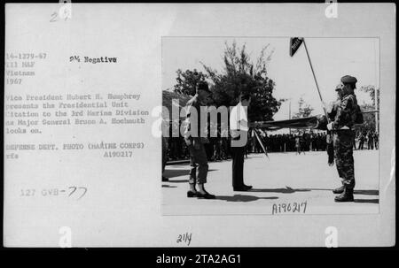 Vizepräsident Hubert H. Humphrey überreicht die Präsidenteneinheit Citation an die 3. Marine-Division zusammen mit Generalmajor Bruno A. Hochmuth in einer Zeremonie während des Vietnamkriegs. Dieses Ereignis wurde in einem offiziellen Foto des Verteidigungsministeriums festgehalten, das die Anerkennung der Bemühungen der Division zeigt. Stockfoto