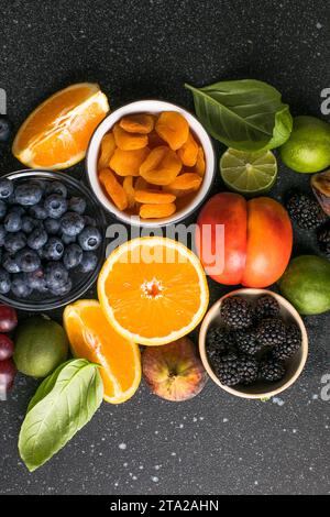 Auswahl an frischen exotischen Früchten und Beeren auf Betontisch, flach gelegen Stockfoto