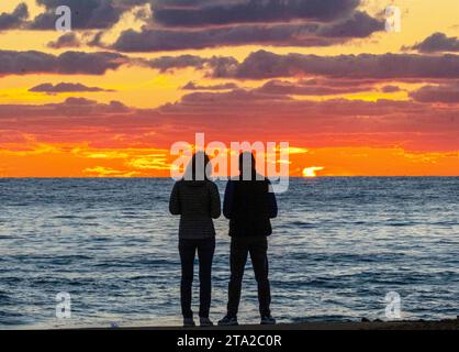 Ein junges Paar beobachtet den Sonnenuntergang über dem Mittelmeer, Paphos, Zypern Stockfoto