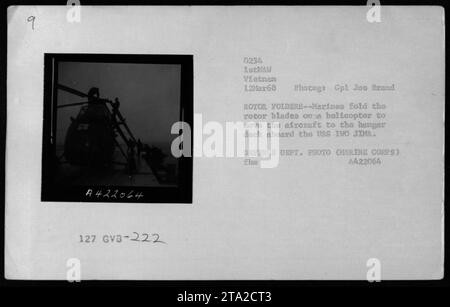 Marines von der 222. Hubschrauberstaffel werden am 12. März 1968 gesehen, wie sie die Rotorblätter von UH-34 Hubschraubern falten. Die Hubschrauber werden vorbereitet, um während des Vietnamkriegs auf das Hangar-Deck an Bord der USS IWO JIMA gebracht zu werden. Dieses Foto wurde von Marine Corps Corporal Joo Brand aufgenommen. Stockfoto