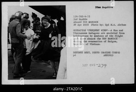 Mitglieder der Flugdeckbesatzung an Bord der USS Hancock unterstützen Flüchtlinge und Munition bei der Operation Frequent Wind bei der Evakuierung von Saigon, Vietnam am 29. April 1975. Dieses Foto, aufgenommen von CPL M.A. Abrham, zeigt die Bemühungen, vietnamesische Flüchtlinge und Militärangehörige aus dem Kriegsgebiet zu evakuieren. Das Foto ist ein offizielles Foto des Verteidigungsministeriums (Marine Corps) mit der Identifikationsnummer A801613. Stockfoto