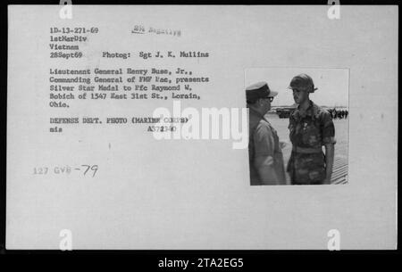 Generalleutnant Henry Buse überreicht die Silver Star Medal an PFC Raymond W. Bobich, einen Marine aus Lorain, Ohio. Diese Zeremonie fand am 28. September 1969 in Vietnam statt. Daneben waren John Warner, Verteidigungsminister Melvin Laird und Norman Vincent Peale. Stockfoto