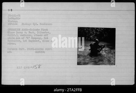 PFC Danny A. Park, Radioman aus Alhambra, Kalifornien, spült ab, während Soldaten der Kompanie, 3. Bataillon, 1. Regiment, während der Operation Adam am 20. Februar 1966 in Vietnam einen Fluss überqueren. Das Foto dokumentiert amerikanische Militäraktivitäten und Flussüberquerungen. Stockfoto