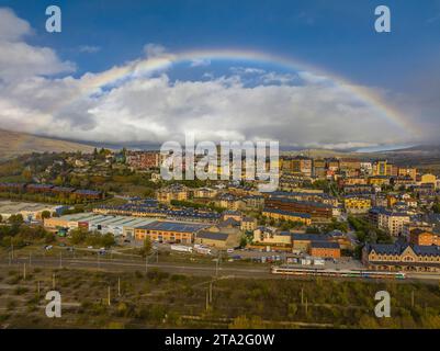 Luftaufnahme der Stadt Puigcerdà umgeben von einem Regenbogen (Cerdanya, Katalonien, Spanien, Pyrenäen) ESP: Vista aérea de Puigcerdà y un arco Iris Stockfoto