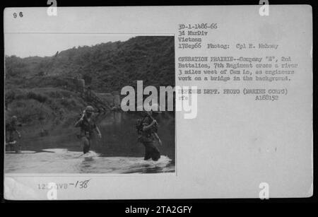 US-Marines von Kompanie E, 2. Bataillon, 7. Regiment, die einen Fluss 3 Meilen westlich von Cam Lo während der Operation Prairie I am 17. September 1966 überquerten. Ingenieure können im Hintergrund auf einer Brücke arbeiten. Foto von CPL R. Mahony. (Foto des Verteidigungsministeriums, mit freundlicher Genehmigung des Marine Corps) Stockfoto