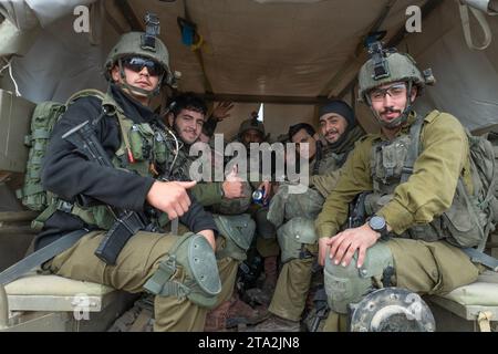 Süd-Israel, Israel. November 2023. Israelische IDF-Soldaten Gesten in einem Humvee, als ihr Übertrager eine Vorwärtsinszenierung im Süden Israels verlässt und am 28. November 2023 in den Gazastreifen zieht. Heute ist der fünfte Tag der Pause oder des Waffenstillstands, des Austauschs israelischer Geiseln aus Gaza und der Rückkehr palästinensischer Gefangener, die Israel hält. Seit den Terroranschlägen der Hamas am 7. Oktober 2023 werden in Gaza noch rund 173 israelische Geiseln festgehalten. Foto von Jim Hollander/UPI Credit: UPI/Alamy Live News Stockfoto