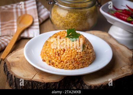 Traditioneller türkischer Bulgur-Pilaf mit Tomatensoße auf dem Teller (türkischer Name; Meyhane pilavi) Stockfoto